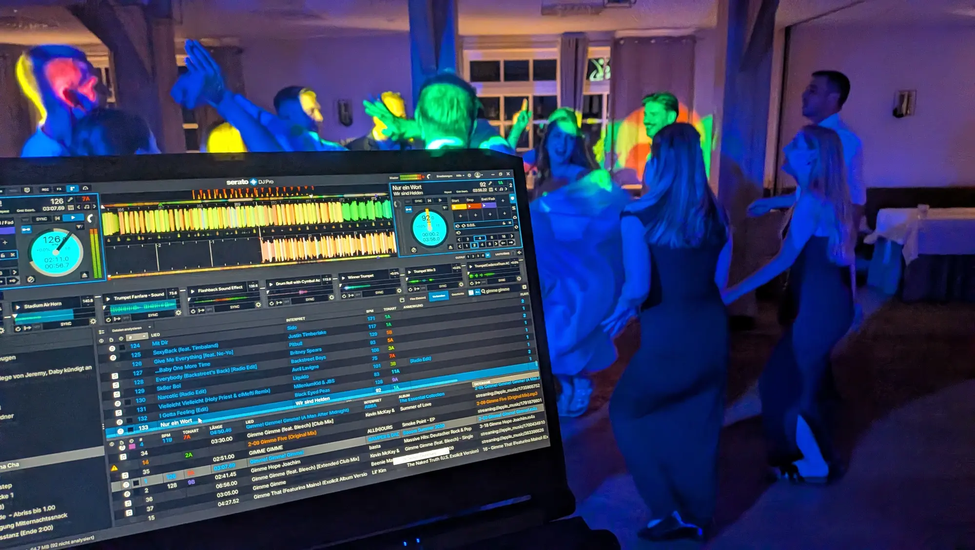 Blick über den DJ-Bildschirm auf die tanzende Hochzeitsgesellschaft